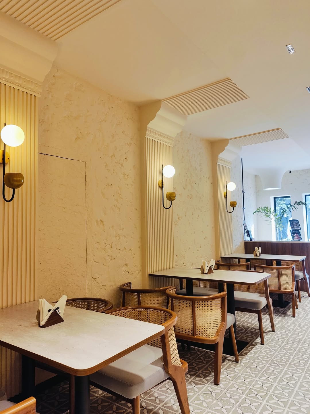 Dining hall with cane chairs and warm sconces